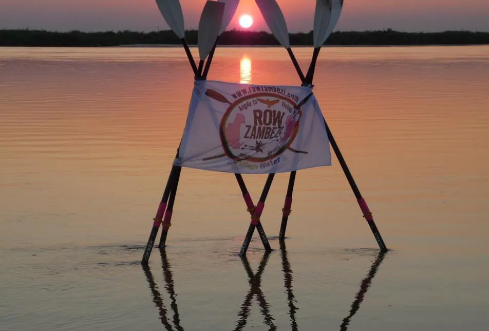 Oars crossed in the shallows at sunset on the river